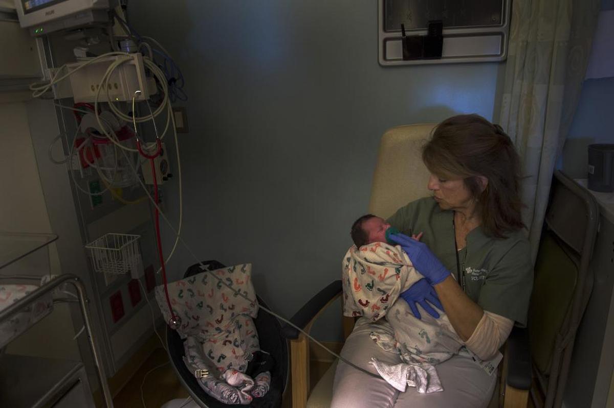 Volunteer Jill Matranga said it’s important to keep the room lights low as she soothes a newborn baby being treated for drug withdrawal in the Neonatal Intensive Care Unit at Sutter Medical Center, Sacramento, on May 4.