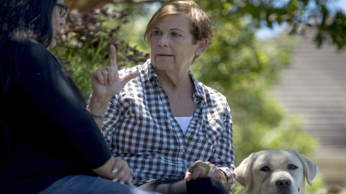 Ellen Thielman signs with interpreter Kylia Kirkpatrick while she pets Benjamin III, a 9-month-old yellow Labrador puppy being trained as an assistance dog at the Northwest regional training center and headquarters of Canine Companions for Independence in Santa Rosa, Calif., on Thursday, June 23, 2016. Thielman is frustrated by the lack of adequate interpreter services during her two recent hospital stays at Mercy General Hospital in Sacramento. None of her medical providers was fluent in sign language.