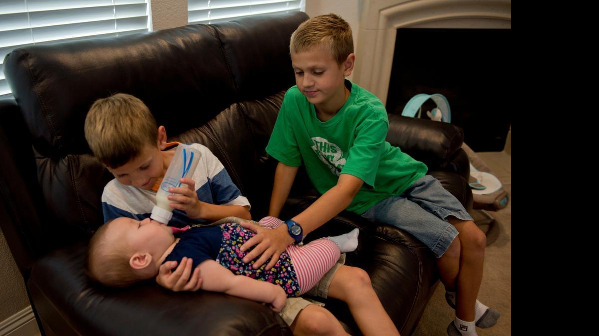 
Simon Hinson, 7, feeds his sister Lucy, 6 months, as brother Justin, 10, looks on Monday September 8, 2014 in Lincoln, Calif. Simon was diagnosed with Autism Spectrum Disorder when he was 15 months old. He participated in the Early Start Denver Model therapy program co-developed by a UC Davis researcher.
