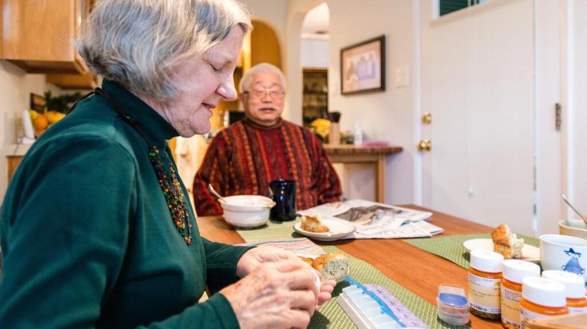 Diana Matsushima, her husband’s primary caregiver, prepares his medication and vitamins at his breakfast on Dec. 22.