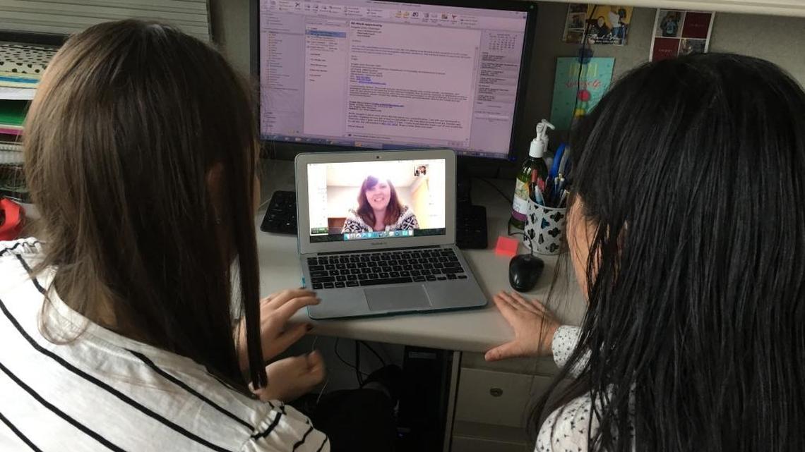 Speech language clinician Amy Banasik (left) and Vivian Nguyen (right) talk to Kristen Lundstrom over Skype about how her son, Tyson, is responding to different speech and language strategies.