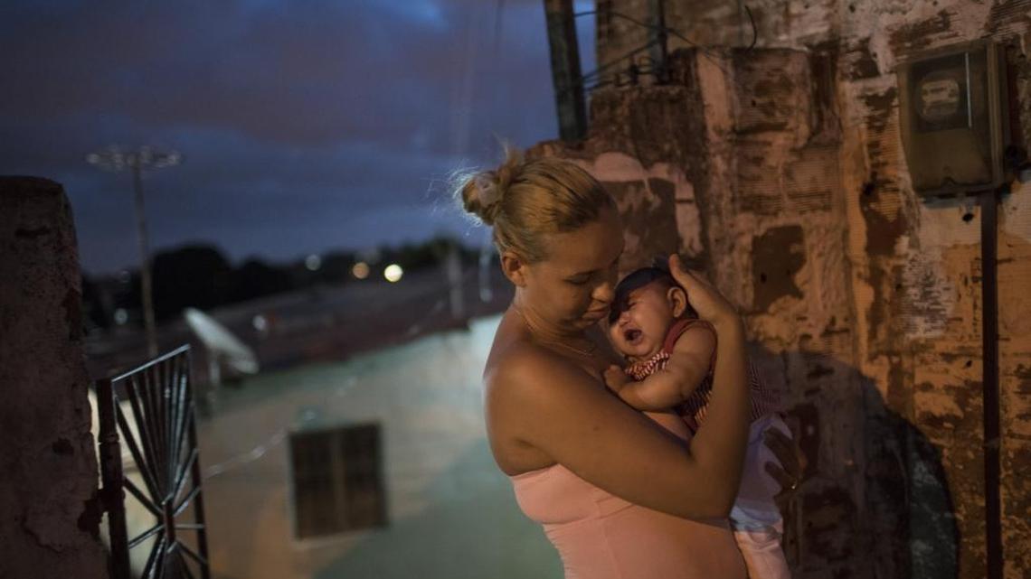Gleyse Kelly da Silva, 27, holds her daughter Maria Giovanna, who was born with microcephaly caused by the Zika virus, outside their house in Recife, Brazil. The disease is now being found in Mexico.