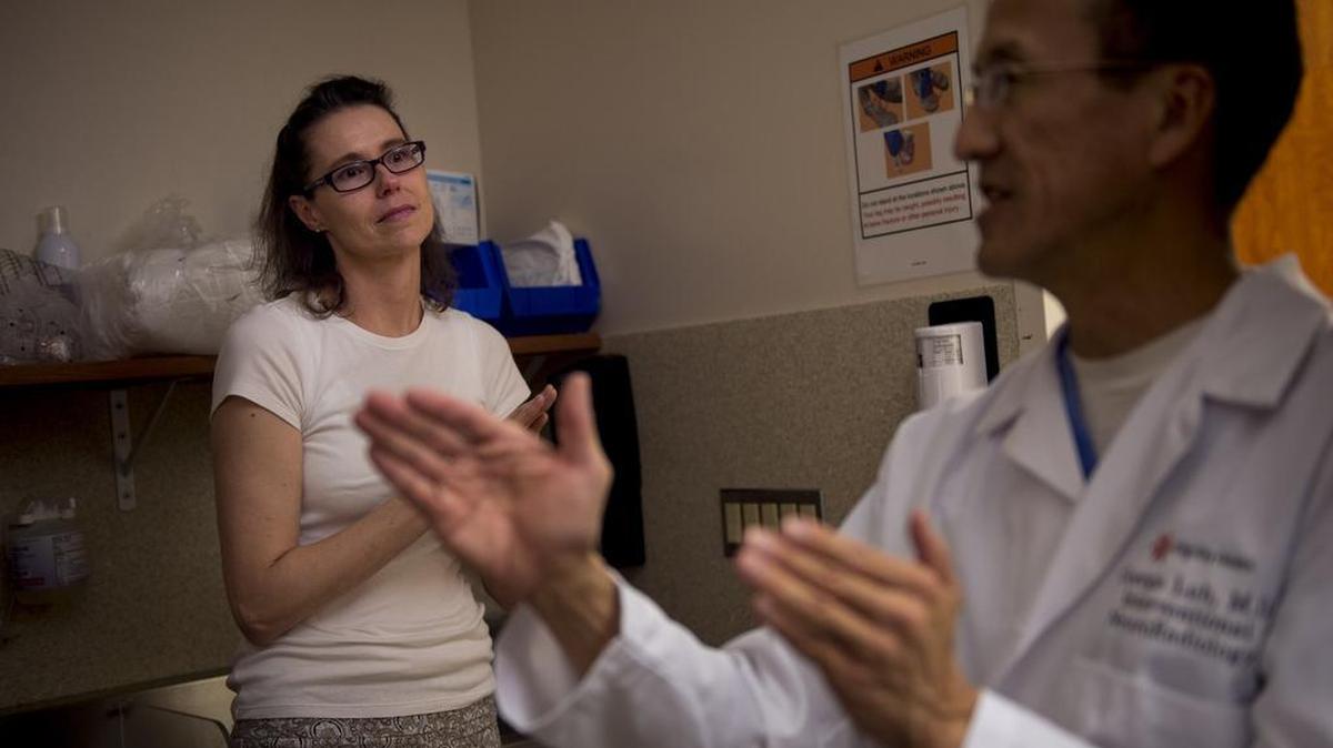 Melissa Logue, who underwent a stroke procedure in January, listens as Dr. George Luh discusses her situation.