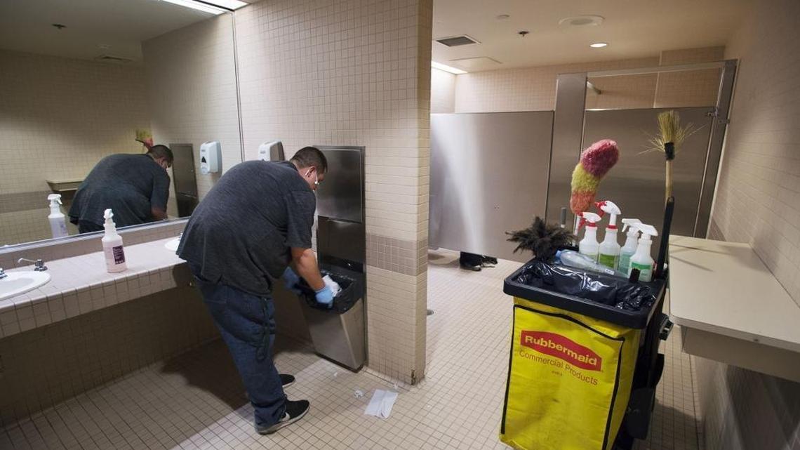 City library janitor Sean Bloom cleans a bathroom where many homeless regularly take advantage of the public area on Friday, May 19, 2017 in Sacramento, Calif.