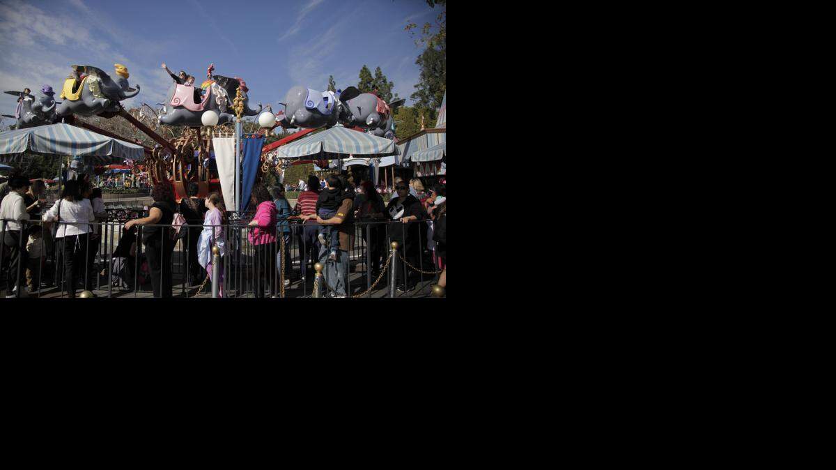 
Visitors wait in line to ride Dumbo the Flying Elephant at Disneyland, Thursday, Jan. 22, 2015, in Anaheim, Calif. Some 131 people have been infected in a measles outbreak that led California public health officials to urge those who haven’t been vaccinated against the disease, including children too young to be immunized, should avoid Disney parks where the spread originated. 
