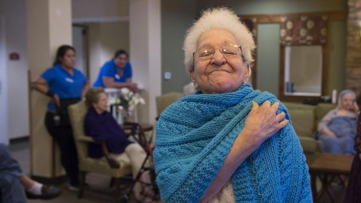 Beatrice Gonzalez enjoys the comfort of a blanket from Alice’s Embrace, a volunteer group that visited Carlton Senior Living in Davis on Sept. 14.