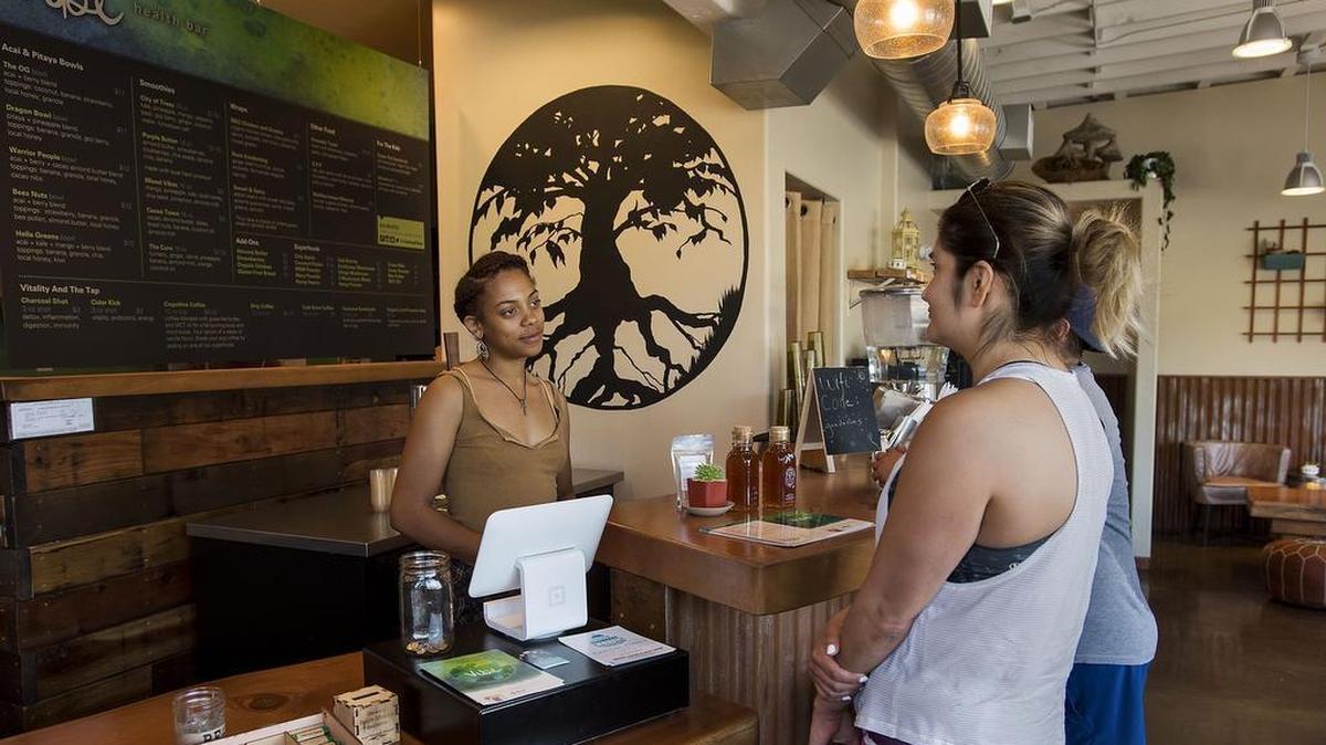 Assistant manager Aliyah Sidqe, left, waits on customers at Vibe Health Bar in Oak Park on Tuesday, Aug. 16, 2016.