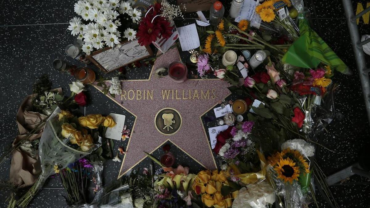 Flowers and memorabilia are piled on Robin Williams’ Hollywood Walk of Fame star in Los Angeles on Aug. 12, 2014, a day after he was found dead.