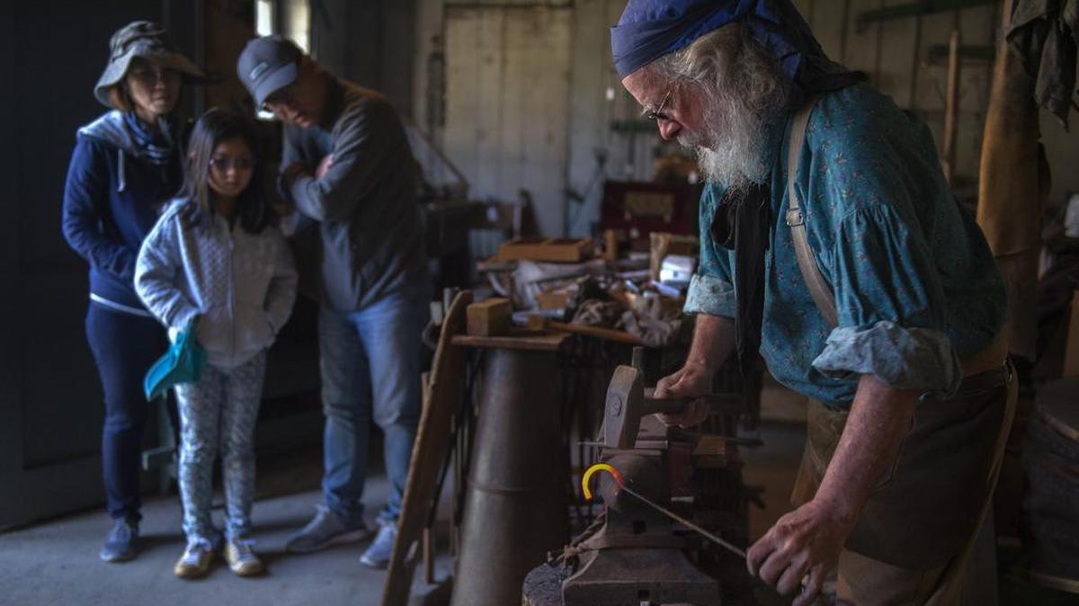 Dennis “Biscuits” Brehm, 69, right, of Sacramento demonstrates his skills as a blacksmith at Sutter’s Fort Traders’ Faire.