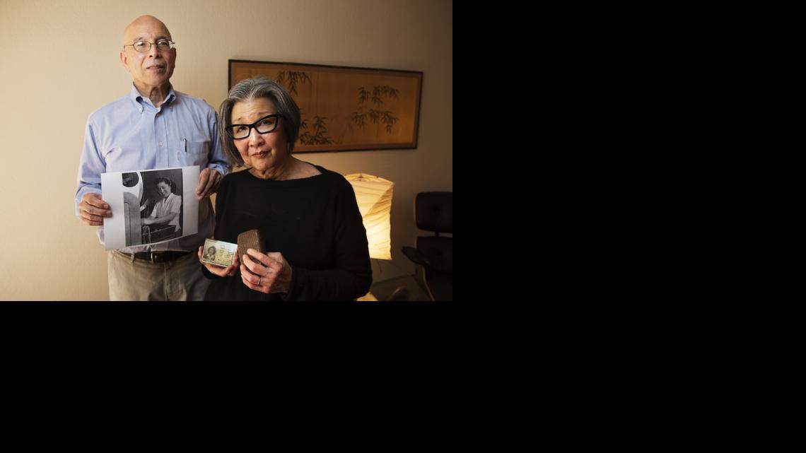 
Local Japanese American activist Yoshinori Toso Himel, holds an image of his mother working at a photo lab in Chicago during World War II that was to be auctioned by a New Jersey auction house, Rago Arts and Auctions. His wife, Barbara Takei, holds her mom’s cigarette holder made from string and her mom’s military ID. 
