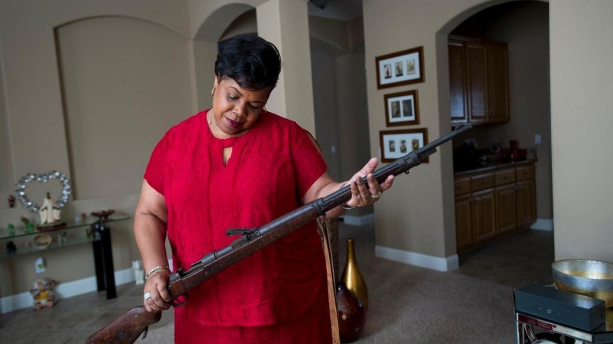 Gina McVey holds a World War I 1915 German Mauser rifle her grandfather brought home from the war and his service under the French military. McVey’s grandfather, Lawrence Leslie McVey, and his all-black regiment – the Harlem Hellfighters – played a critical role in liberating France from the Germans in World War I.