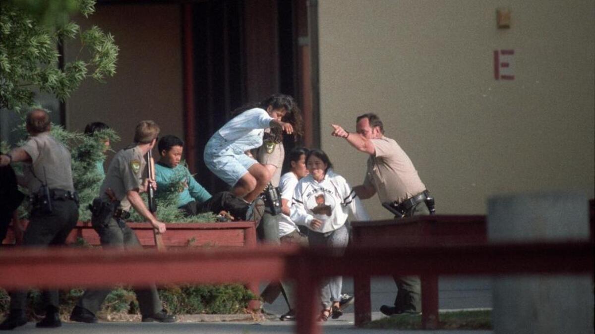 Law enforcement officers assist in the evacuation of students at Lindhurst High School in Olivehurst after heavily armed former student, Eric Houston, took hostages on the campus on May 1, 1992. Houston killed teacher Robert Brens and three students, and wounded 10 others.