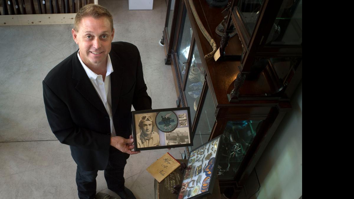 
Brian Witherell holds a photo with a patch and other World War II items that belonged to the late insurance company founder James O. Burpo and will be auctioned by Sacramento-based Witherell’s as part of its “Western Design” auction running from May 1 to 15.
