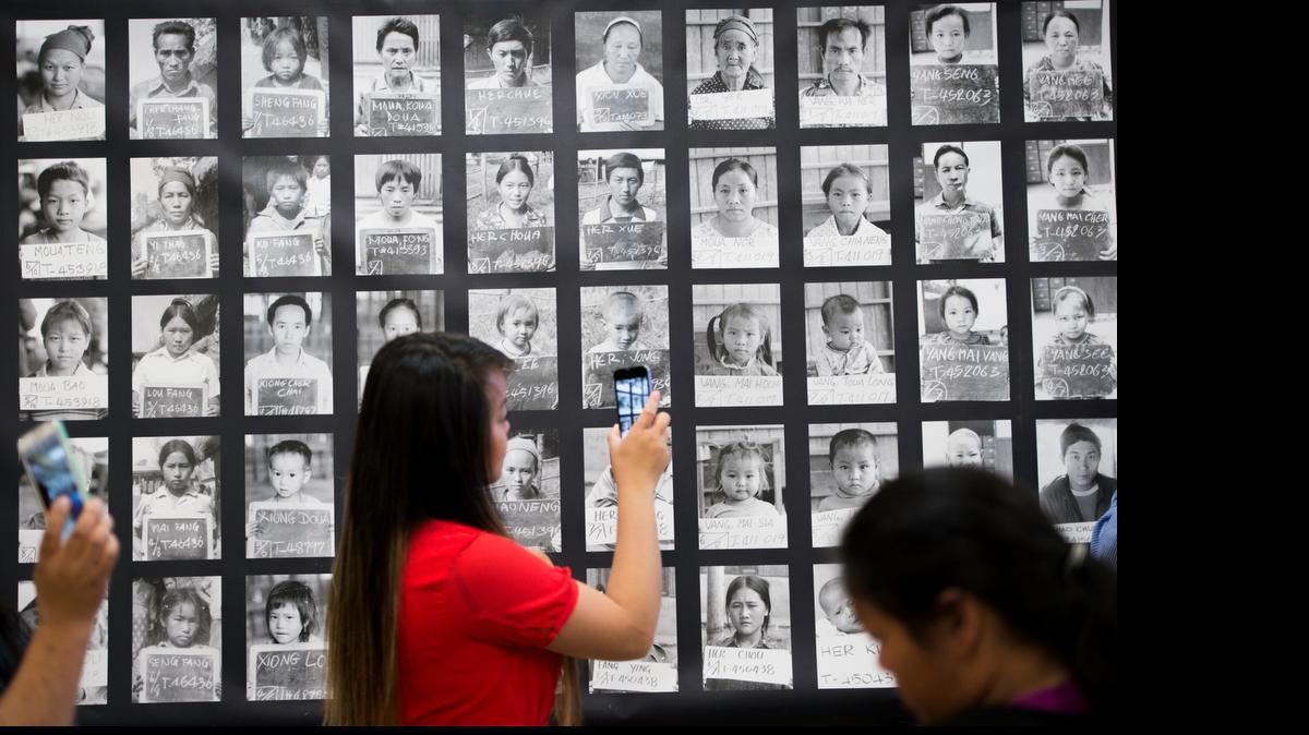 
Maika Xiong takes video of the identification photographs of Hmong refugees in the Thailand refugee camps at a preview of the “Hmong Story 40” project Sunday at Will C. Wood Middle School in Sacramento. The exhibit and photo gallery commemorates 40 years of Hmong people living in the United States.
