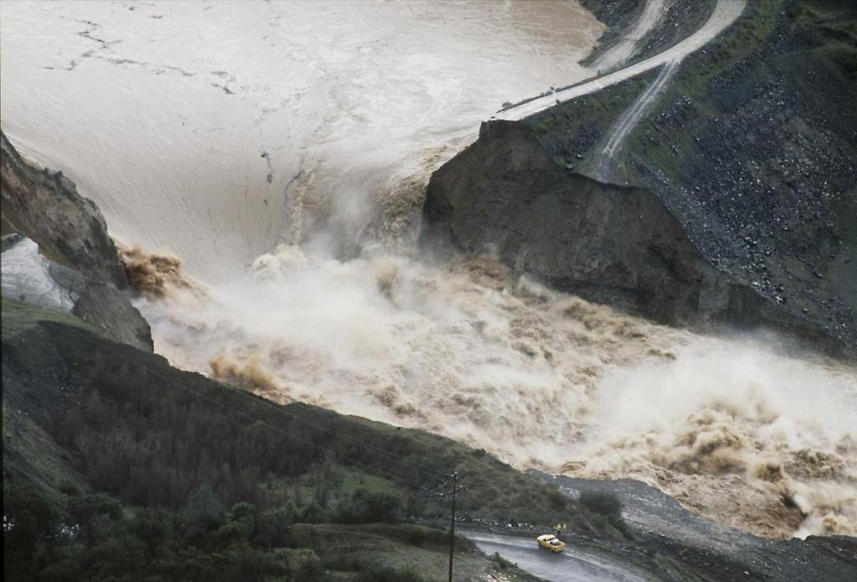 Raging water spews through a coffer dam that collapsed on the North Fork of the American River and dwarfs a pickup truck on Feb. 18, 1986.