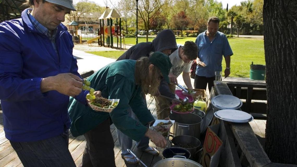 In 2007, Mario, far left, and Steve Inness, second from left in green, a volunteer with Food Not Bombs, dish up for themselves a free vegetarian meal offered by Food Not Bombs at Central Park in Davis. The meal was available to anyone, but mostly drew homeless residents. City officials say the homeless population has increased in the past few years and are considering a new tax to pay for services. The Sacramento Bee/Anne Chadwick Williams/ March 18, 2007