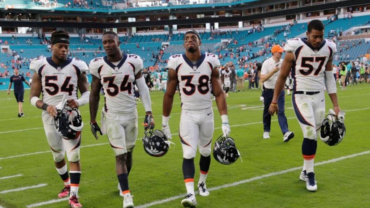 Denver Broncos inside linebacker Brandon Marshall (54), defensive back Will Parks (34), cornerback Marcus Rios (38) and defensive end DeMarcus Walker (57), leave the field after an NFL football game against the Miami Dolphins, Sunday, Dec. 3, 2017, in Miami Gardens, Fla. The Dolphins defeated the Broncos 35-9.