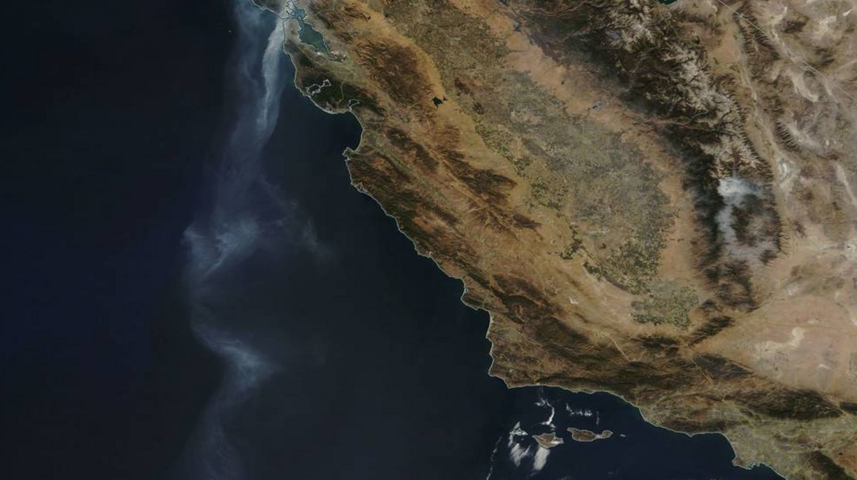 A photo captured Friday by NASA’s Terra satellite shows a stream of smoke extending from the Wine County fire in Santa Rosa and Napa more than 500 miles south into the Pacific Ocean off San Diego.