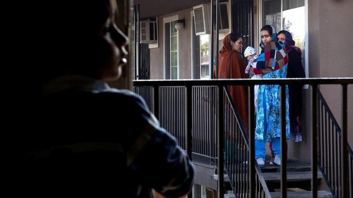 Malalai Rafi, far right, joins other Afghan women to bid good-bye to Mohammad Eltaf Stanizai, 5 ½, left, and his family as they move from Skyview Villa apartments in Arden Arcade in November of 2015. Stanizai's family did not feel safe living in the complex.