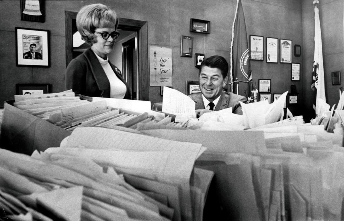 California Gov. Ronald Reagan sorts through some of the approximately 100,000 letters he received after taking office in January 1967. He is assisted by his personal secretary Kathrine Davis.