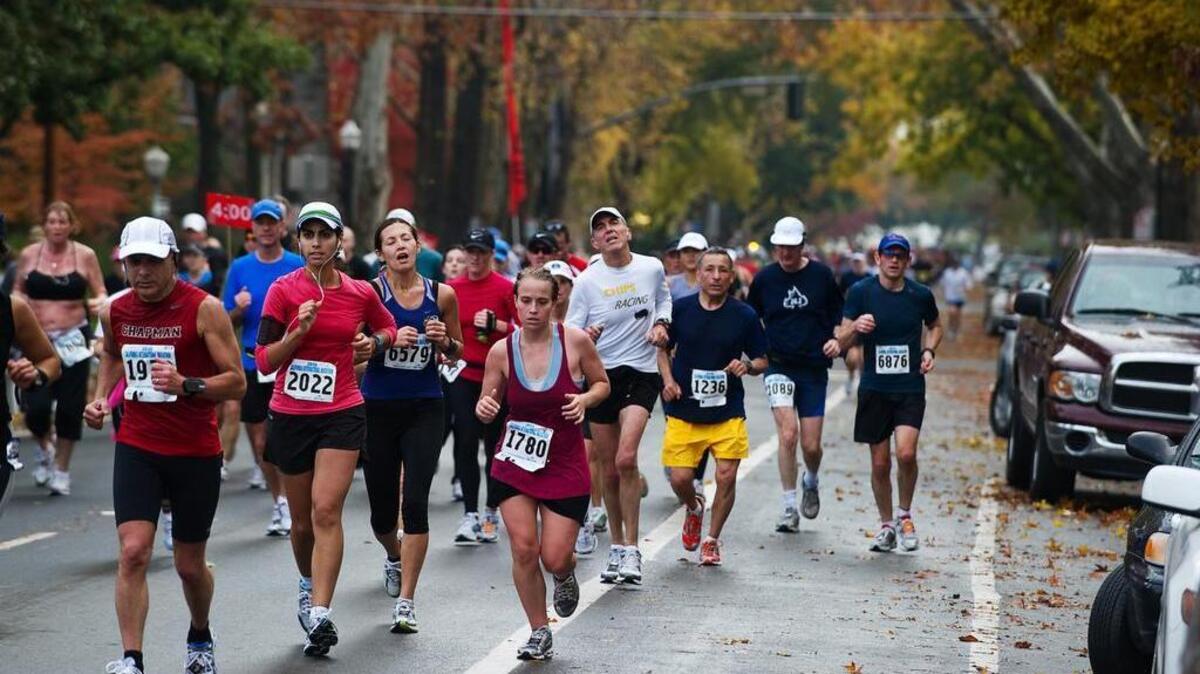
Runners pass the 25-mile mark on L Street in midtown Sacramento during the 2010 California International Marathon, not far from where the street crosses train tracks. Union Pacific has agreed to halt its trains during this year’s race.
