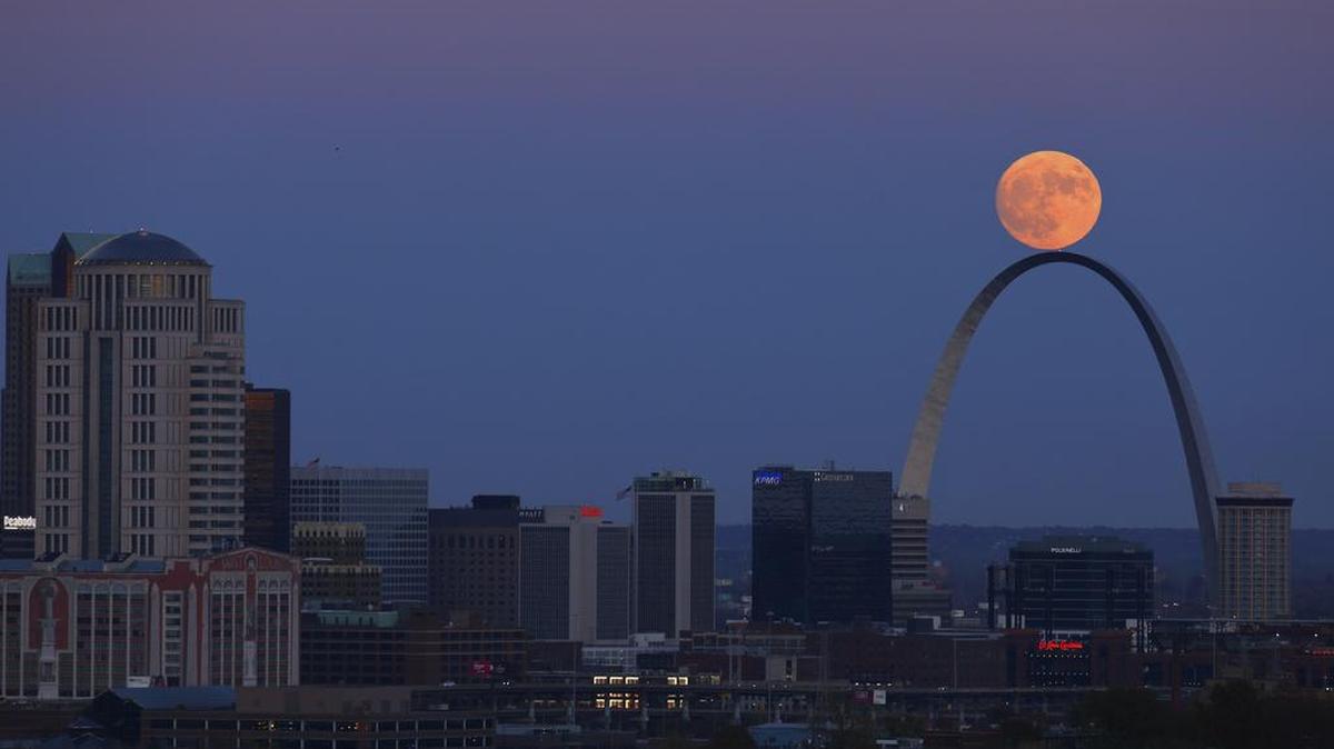 The moon rises beyond the arch in St. Louis as seen from the Compton Hill Water Tower Nov. 13, 2016. Here’s when to catch the peak of this weekend’s Harvest Moon.