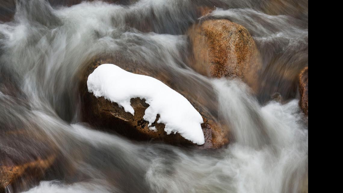 
A snow-covered rock is surrounded by flowing water near the headwaters of the south fork of the American River at Strawberry.

