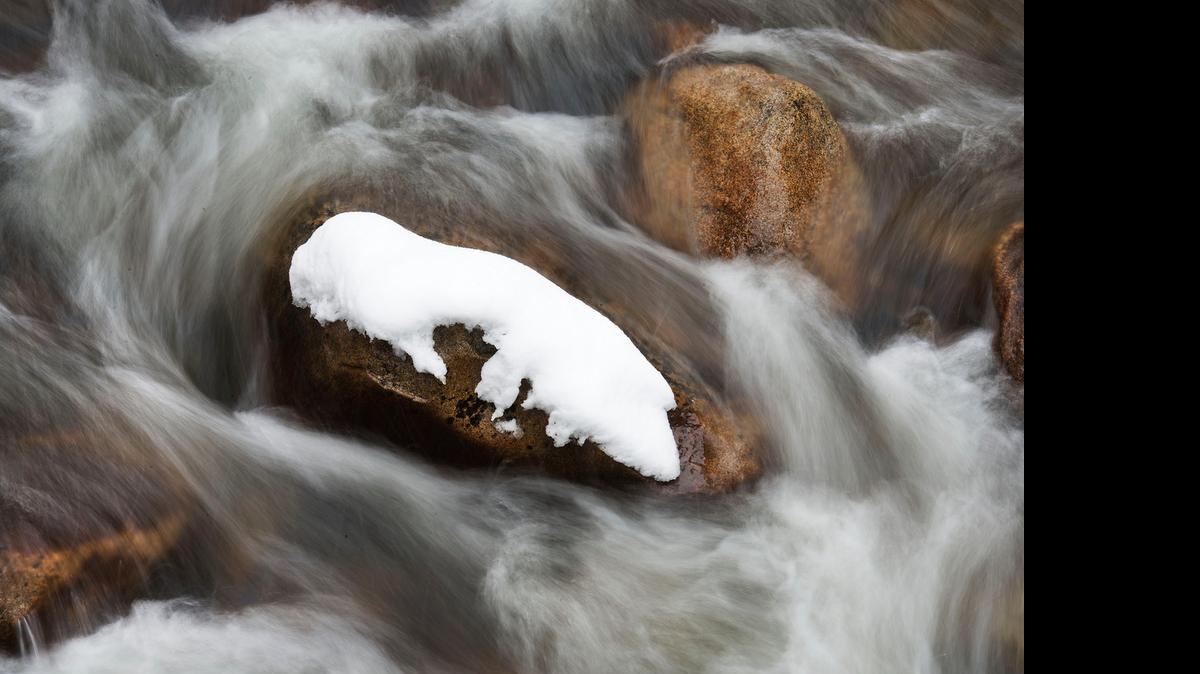
A snow-covered rock is surrounded by flowing water near the headwaters of the south fork of the American River at Strawberry.
