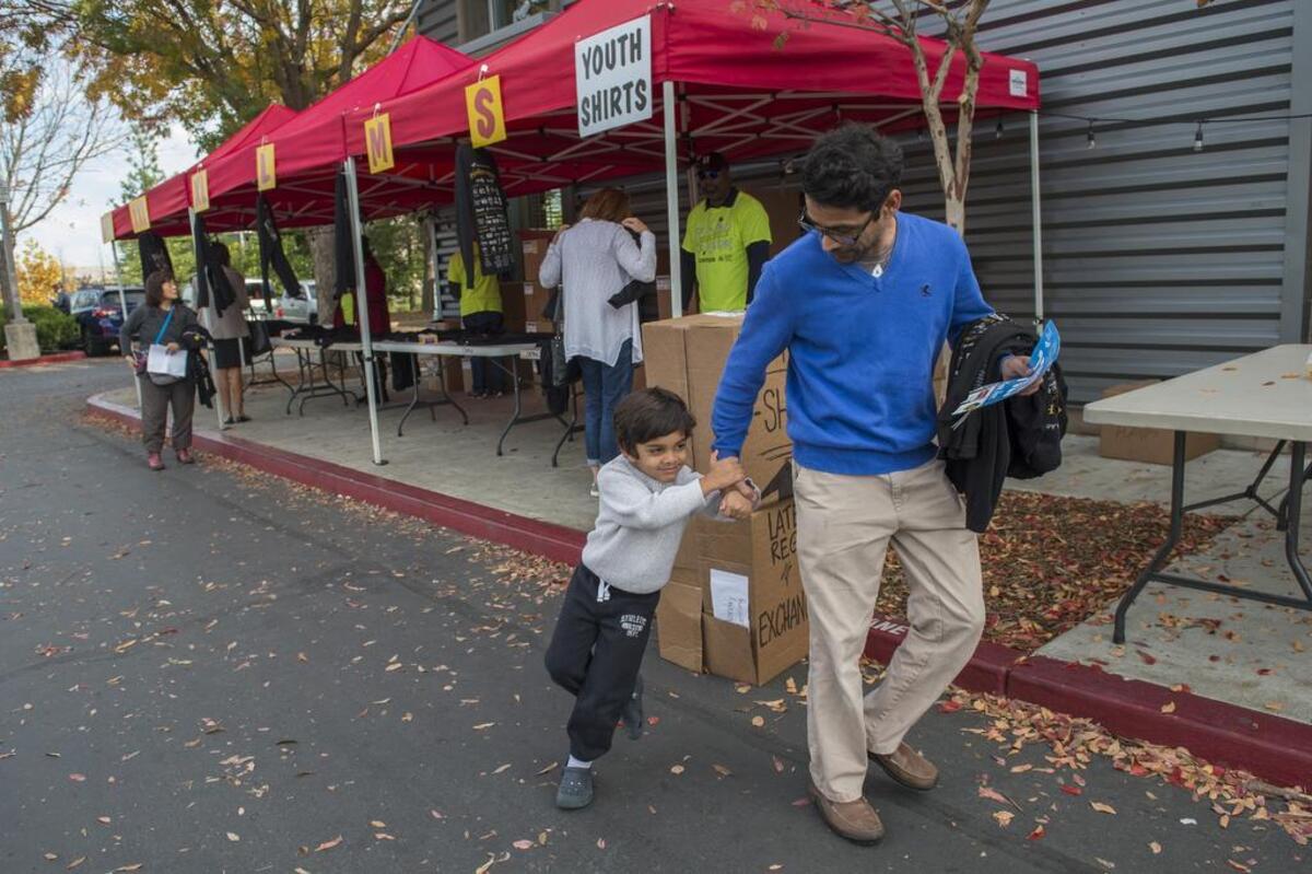Ajay Rambhia, 47, pulls his son Smit Rambhia, 5, after they picked up their Run to Feed the Hungry t-shirts at REI in Sacramento on Wednesday, Nov. 22, 2017. They will run tomorrow in the fundraiser.