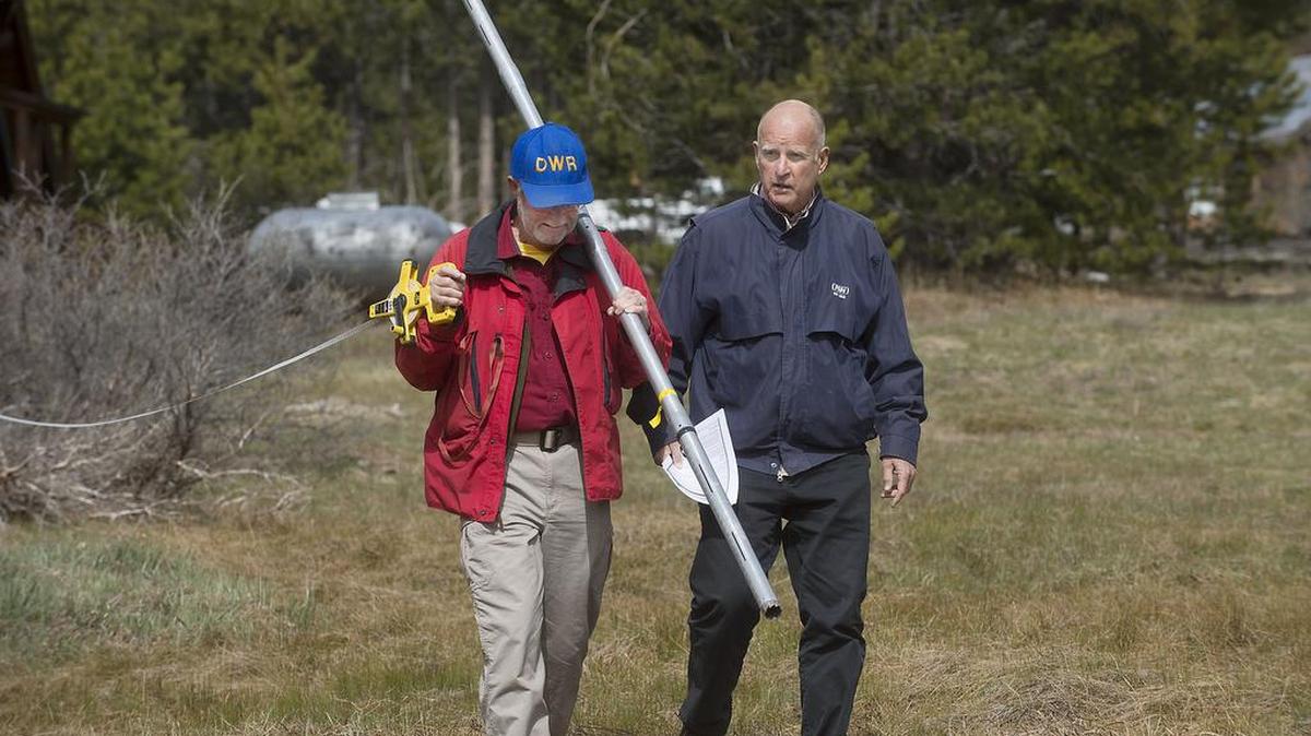 State employee Frank Gehrke and then-Gov. Jerry Brown walk through Carol Pearson’s drought-plagued meadow near Echo Summit in April 2015. This year’s April snowpack could approach low levels.