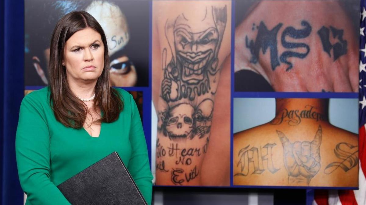 White House press secretary Sarah Huckabee Sanders stands in front of pictures of MS-13 gang tattoos during a press briefing at the White House in Washington on July 27.