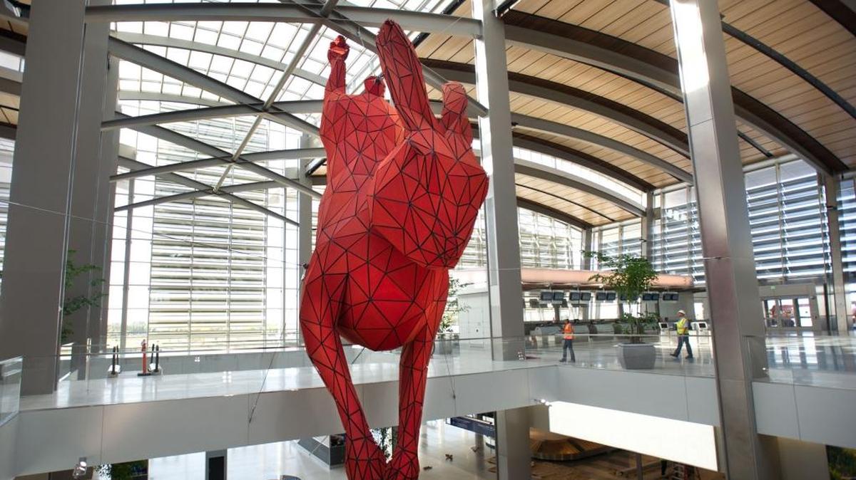 “Leap,” the 56-foot-long red rabbit seen inside Sacramento international Airport’s Terminal B, was created by Denver artist Lawrence Argent.