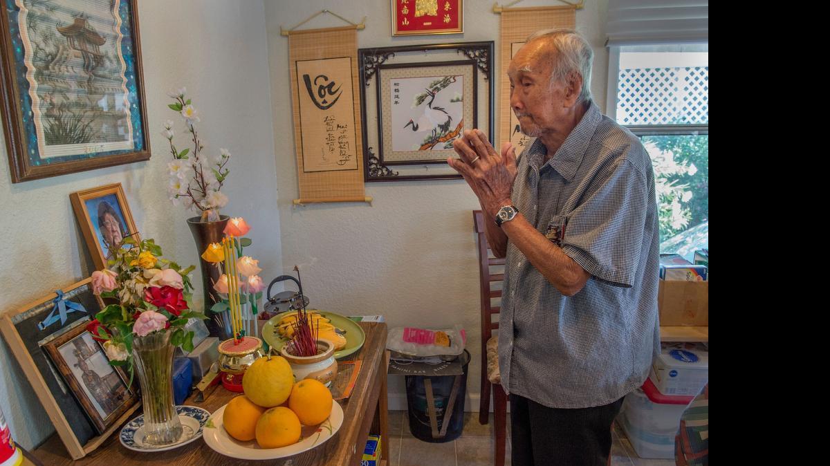 
Nhuong Tran, 93, prays at his wife Khai Phan’s altar Sunday. They were married for 70 years.

