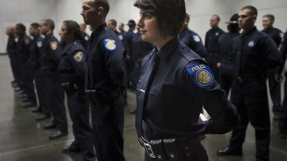 
Emily Kane, center, prepares for the Sacramento Police Department graduation ceremony at the Convention Center in Sacramento on Dec. 19, 2013. The city of Sacramento won a federal grant this week to hire 15 additional officers.
