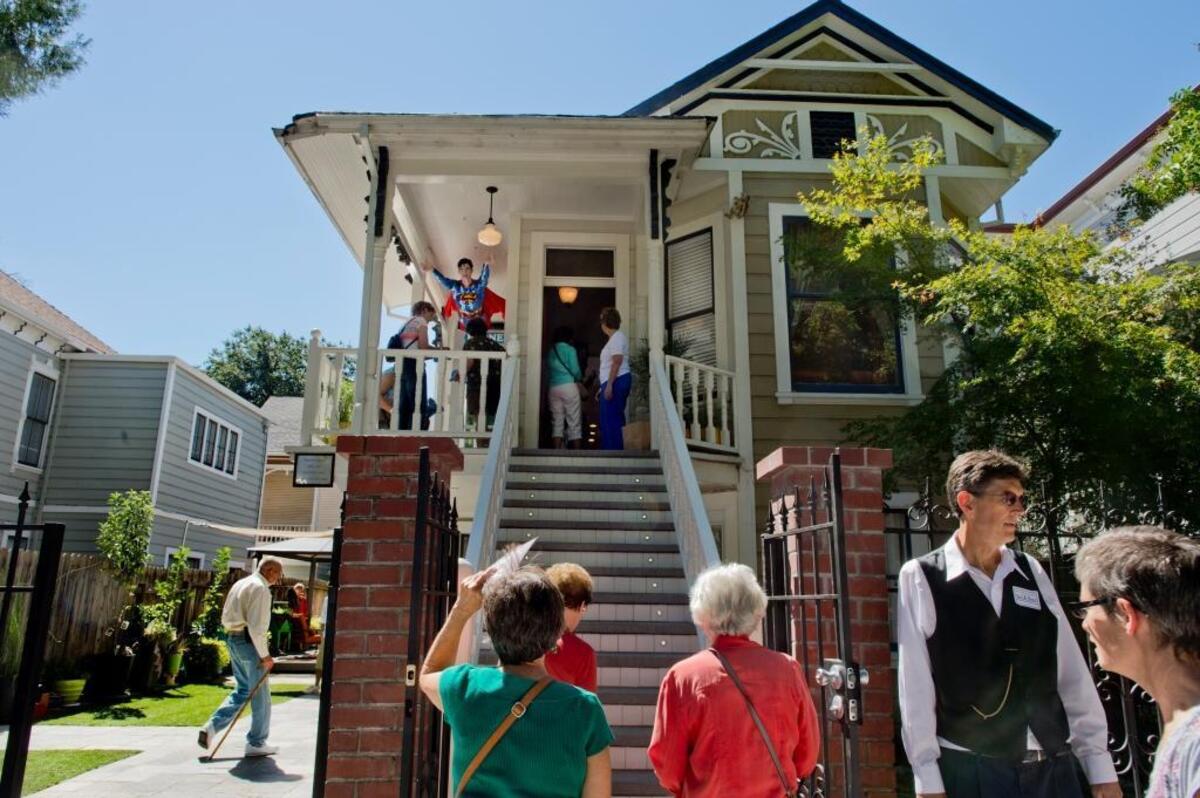 A stream of people tour Dorothea Puente’s former home on Sept. 15, 2013. Seven victims were found buried in property’s yard.
