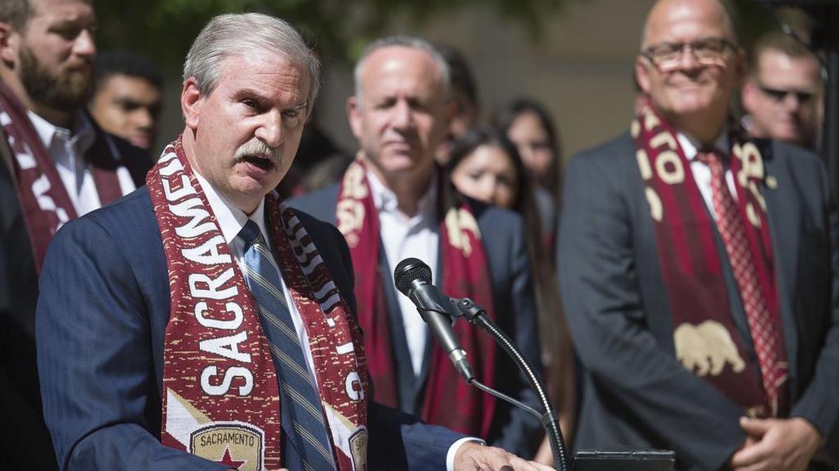 Republic FC CEO and Chairman Kevin Nagle, left, flanked by Mayor Darrell Steinberg, center, speaks during a press conference outside City Hall on May 15, 2017 in Sacramento.