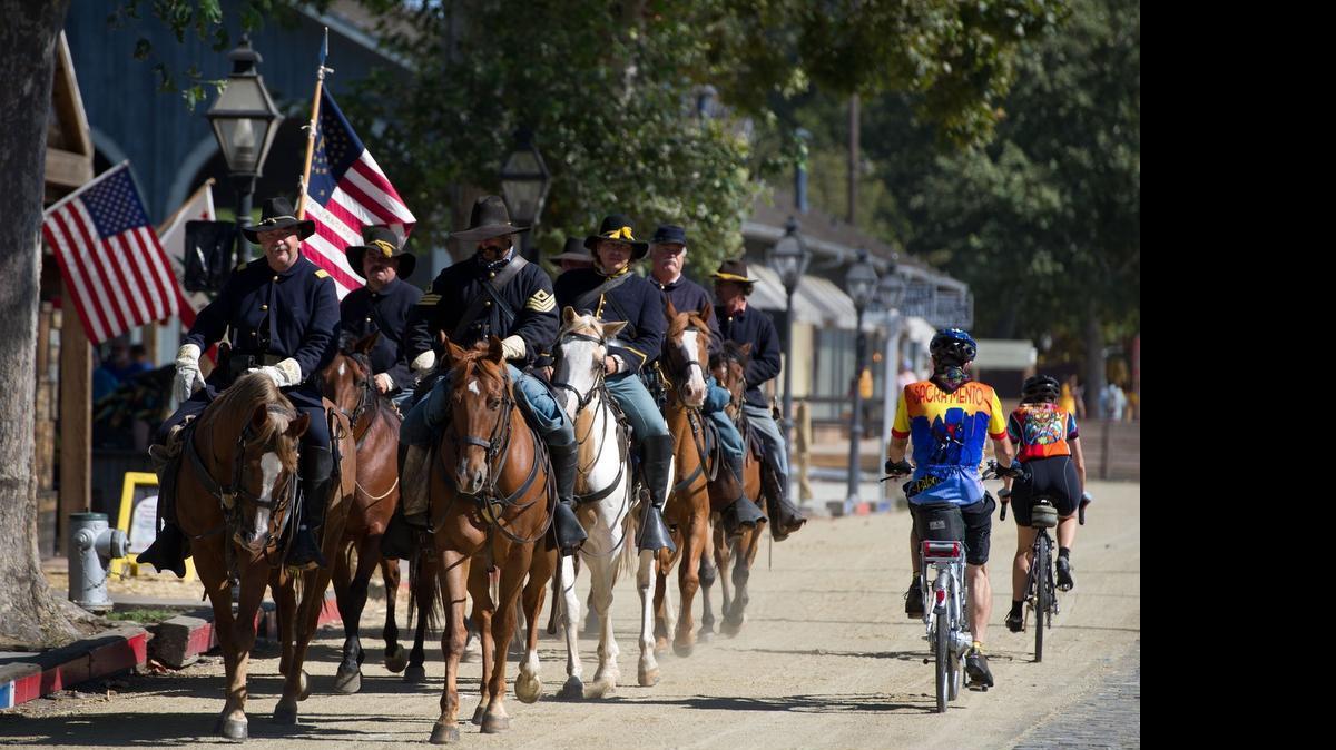 
Members of Company F, 2nd Calvary - locally known as the Sacramento Rangers during the 1800's - are passed by cyclists on Front Street on Sept. 3, 2011. Gold Rush Days is set to return to Old Sacramento this year.
