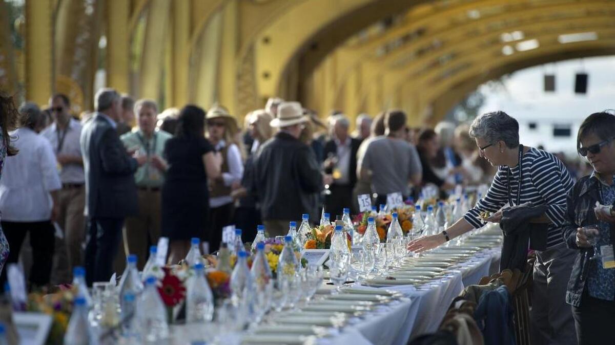 Guests mingle on the roadway before sitting down for a meal during the ‘Farm-to-Fork’ private dinner on the Tower Bridge in Sacramento on Sunday, September 29, 2013.