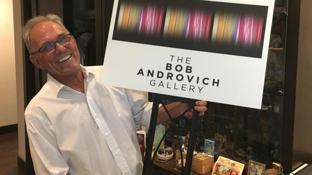 Bob Androvich holds a sign he used to place in front of his Land Park home for his art shows. After the city told him he couldn’t sell his art from his home without a permit, Androvich took a two-month break from the shows. He plans to return this week, showcasing the work of six local artists.