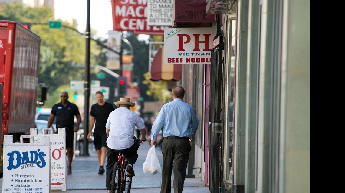 
A bicycle rider mixes with pedestrians on a J Street sidewalk in downtown Sacramento, creating a potentially dangerous situation.
