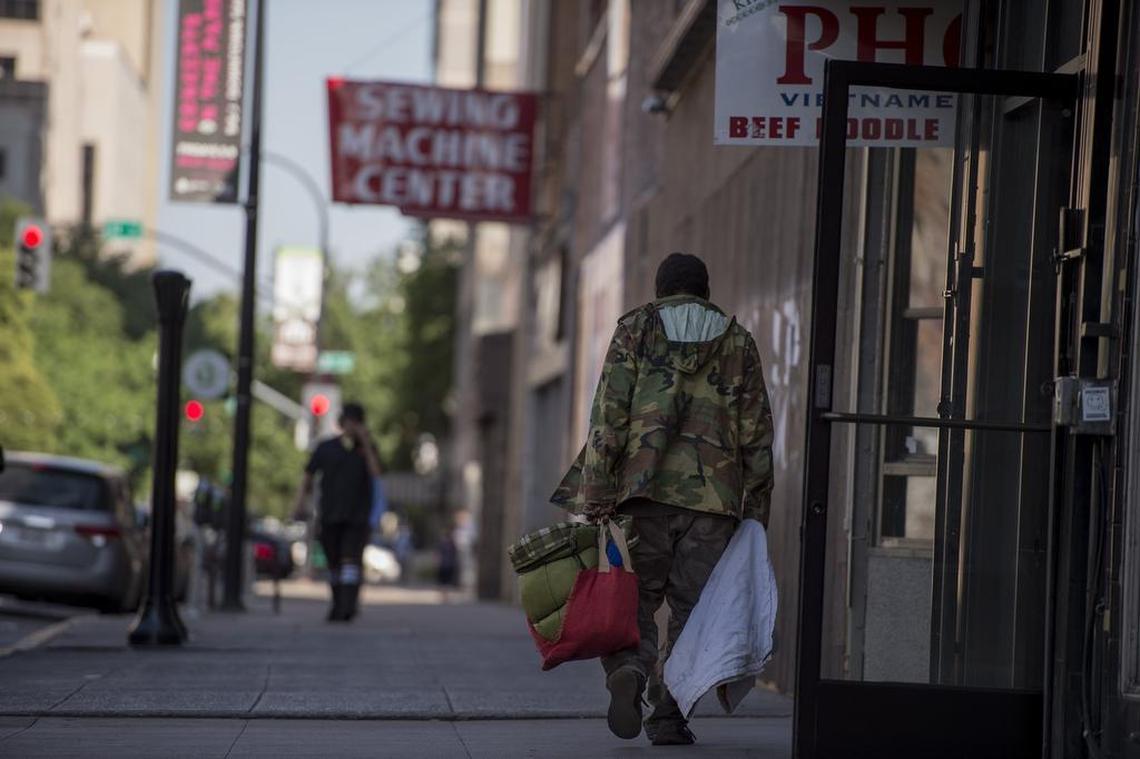 A homeless man walks down J Street between 10th and 11th streets on Monday in Sacramento. Despite pockets of renewal in other spots of downtown, several buildings in the 1000 block of J Street sit vacant.