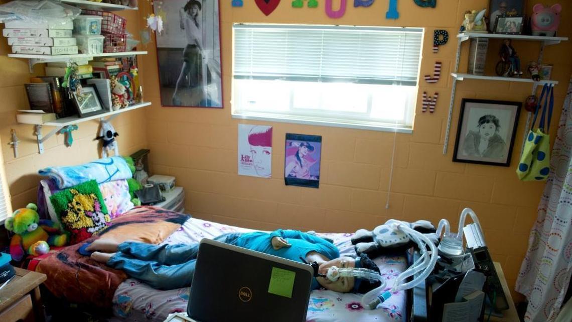 
With a poster of Taylor Swift hanging in her bedroom, Priscilla Wong lies in bed and uses her computer to make artwork Tuesday. The 23-year-old UC Davis graduate lives with a rare muscular disease and spends much of her life in solitude, but she feels compelled to create art.
