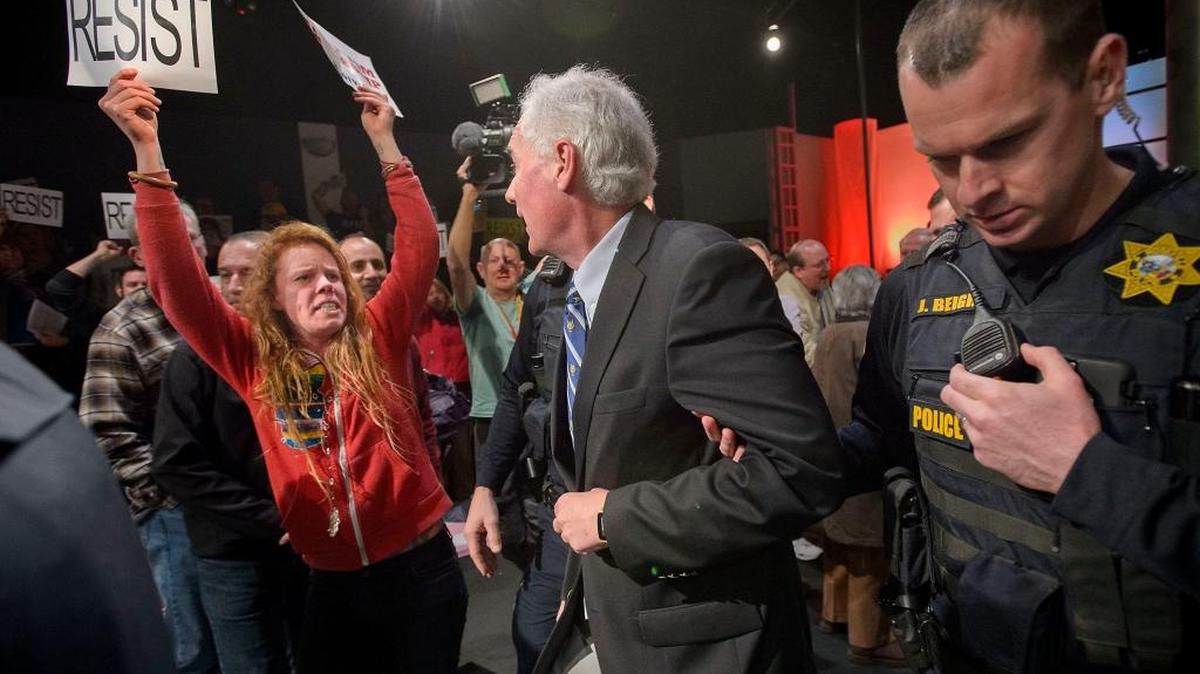Rep. Tom McClintock, R-Elk Grove, center, is escorted by Roseville police through protesters outside Tower Theatre in Rosevillle on Saturday, Feb. 4, 2017. He held a town-hall meeting at the theater and hundreds of anti-Trump demonstrators chanted slogans and carried signs outside.