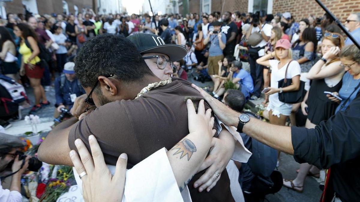 Brittney Cain-Conley, lead organizer for Congregate Charlottesville, with hat, gets a hug from a supporter after she addressed the crowd during a vigil on Sunday for the victims of an attack on Saturday in Charlottesville, Va. A car plowed into a crowd of people protesting a white supremacist rally on Saturday, injuring over a dozen people. In the Sacramento area, two vigils are planned for Sunday night.