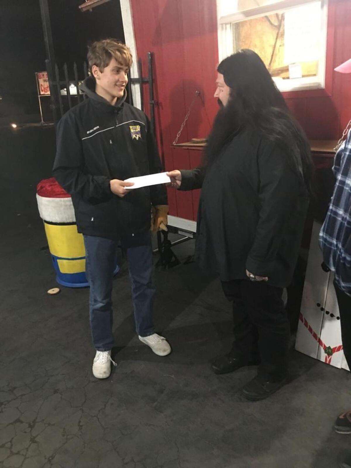 Emerald Tattoo and Piercing operations manager Russ McSwain gives Troop 59 a $200 check after someone stole from the Boy Scouts’ tip jar.