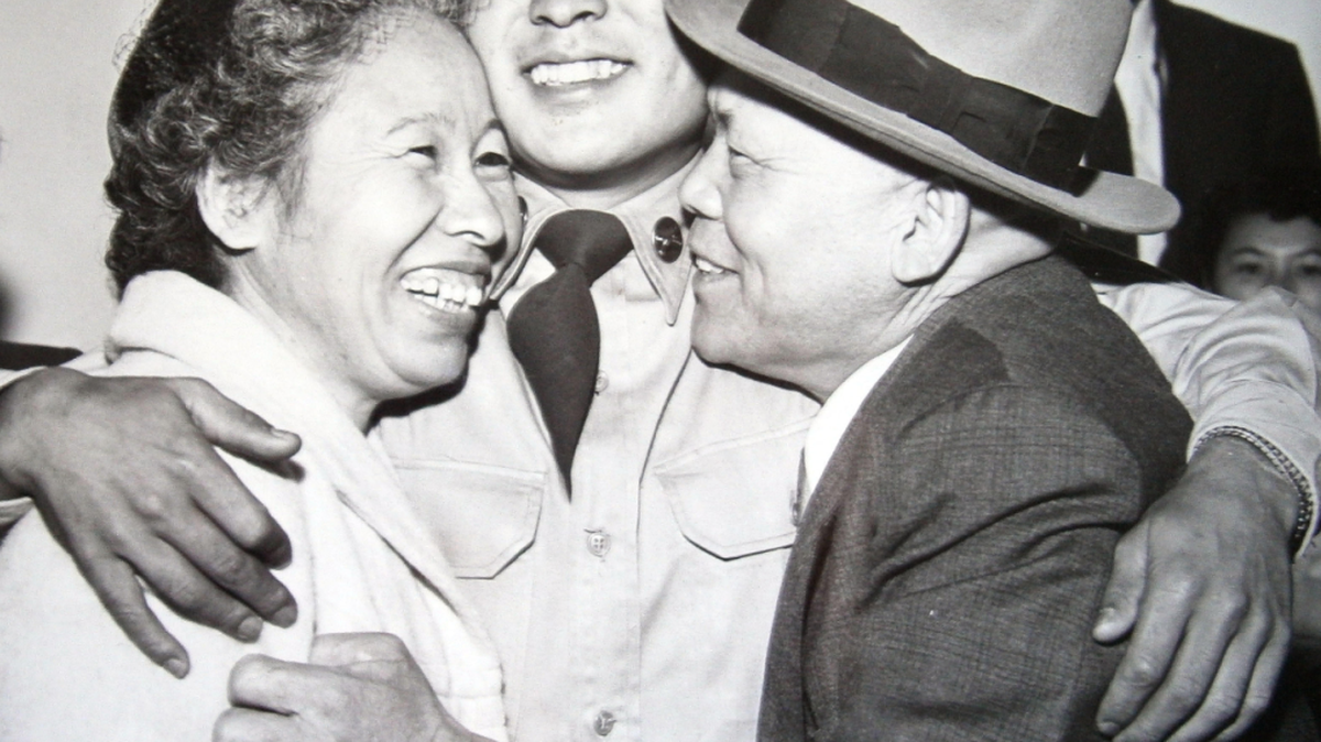 Billy Hatano is greeted by his father and mother, Yoshimasa and Yaeko Hatano, during a homecoming celebration in San Francisco on Aug. 24, 1953.