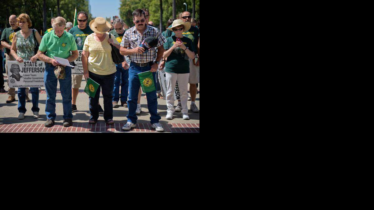 Supporters for the State of Jefferson bow their heads in prayer in front of the California Capitol on Thursday, Aug. 28, 2014, in Sacramento, Calif. They were there to pass out declaration of separation papers to lobbyists.
