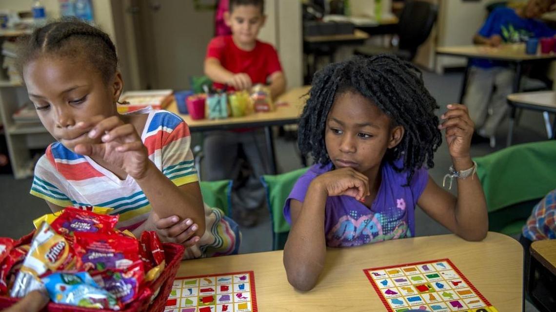 Az’Jah Jones, 8, left, selects a snack as Winajea Moton, 8, right, looks on while playing a geographic bingo game at Mustard Seed School for the homeless on Thursday, Oct. 13, 2016, in Sacramento. At one time everyone in the class was living in a car or tent, said school director Casey Knittel. Average enrollment at the school used to be between 15 and 30 kids per day. In September, enrollment peaked at 66 children, Knittel said. In the back center is Nathaniel Costa-Reid, 9.