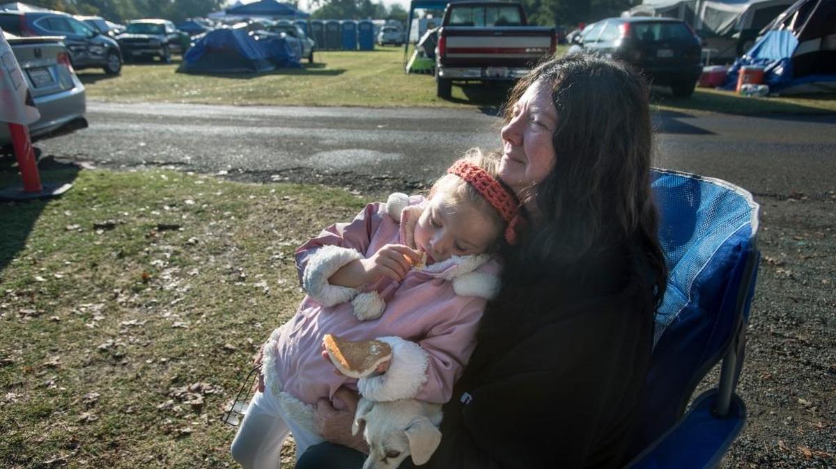 
Katie Pannell, 56, holds her dog Cloe as granddaughter Willow Blossom Stephens, 5, eats a pancake Thursday at the Valley fire evacuation center set up at Napa County Fairgrounds in Calistoga. Seven of her family members fled the Valley fire.
