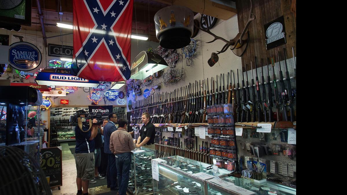 
Assistant Manager Jake Shockley speaks with members of the press beneath the store's Confederate battle flag at Wild Bill's Old West Trading Co. in Elk Grove on Friday, July 3, 2015. Protesters demonstrated in front of the gun shop denouncing the store's display of a Confederate battle flag. The shop's general manager reported that the establishment had been threatened with arson because of the flag.
